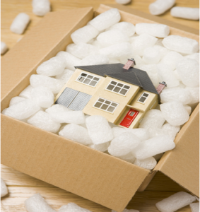 miniature house packed in a cardboard moving box